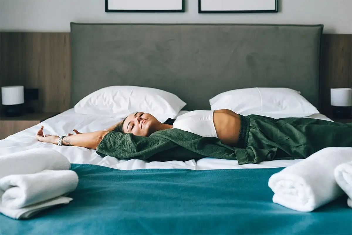 Woman lying stretched out on a bed in the morning (Olga Rolenko/Getty Images)